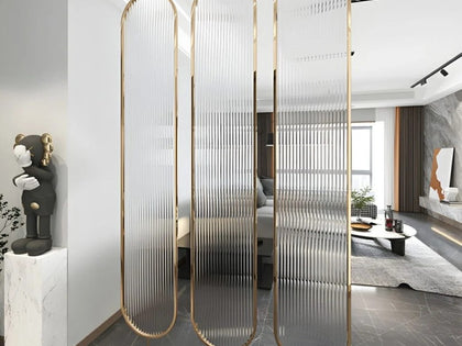 SS PVD gold-frame partition with frosted ribbed glass panels in a modern living room